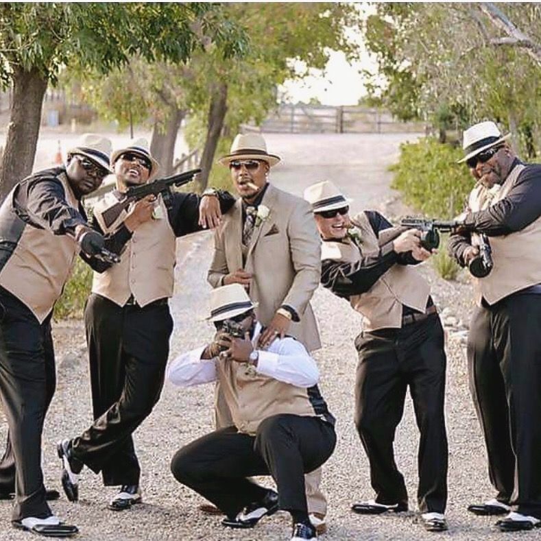 Bride in white gown with veil, surrounded by bridesmaids in mint green dresses, looking out a window.