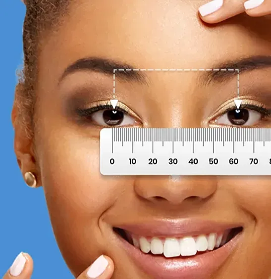 Woman with ruler measuring her eyes, smiling, gold eyeshadow, blue background.
