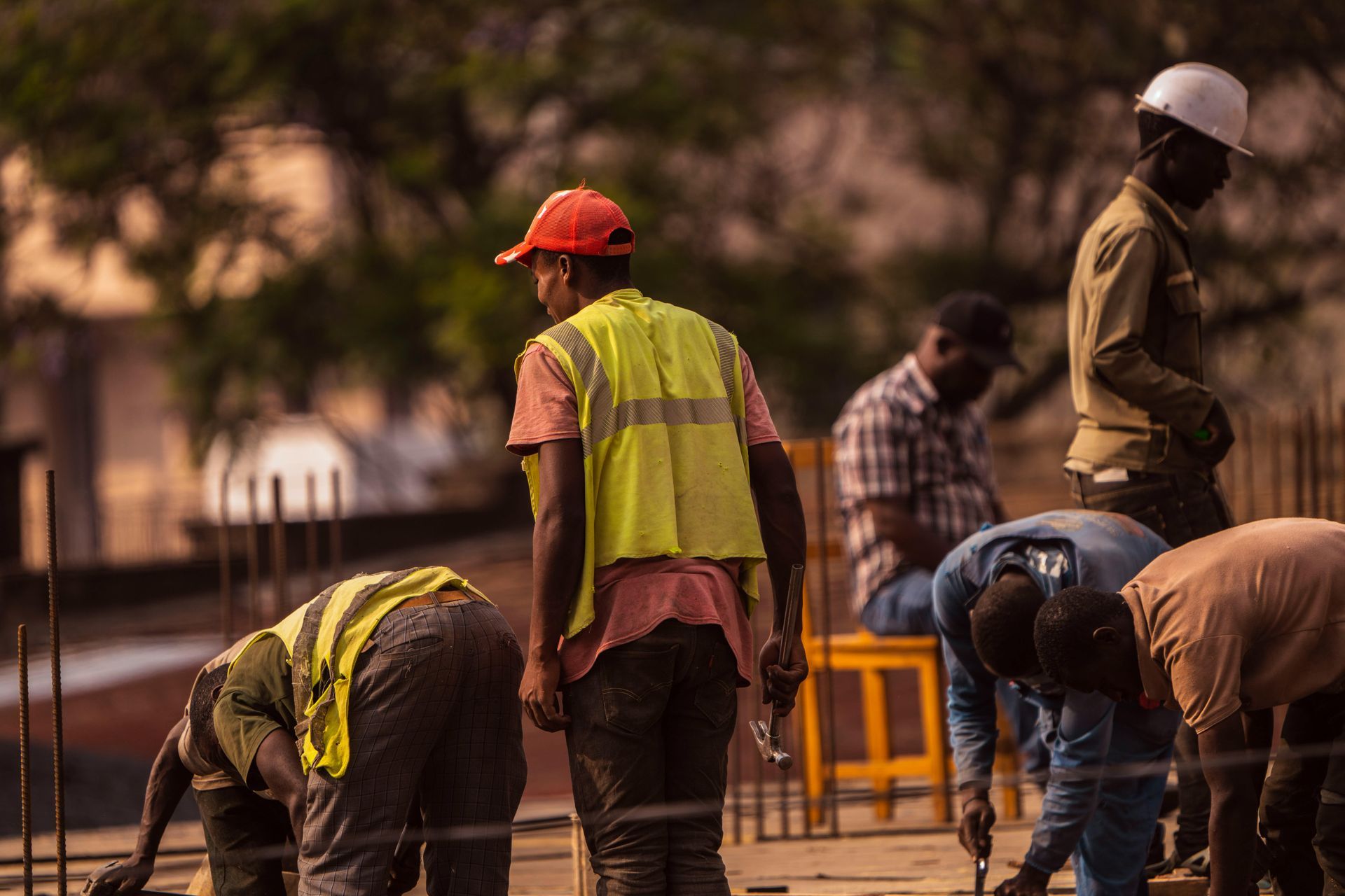 A man is laying on the floor fixing a sink in a kitchen.