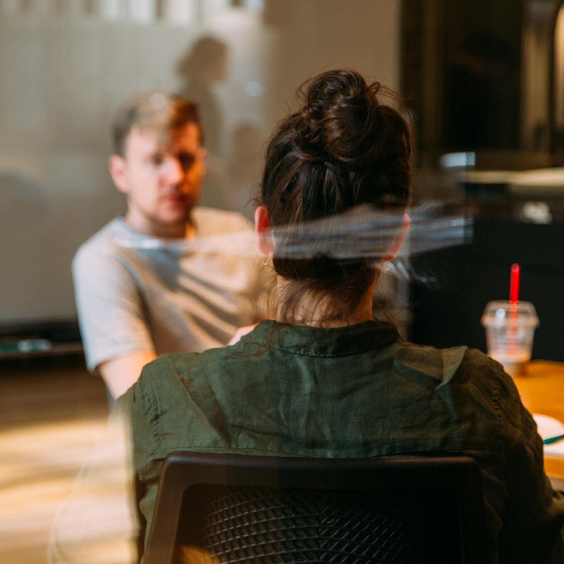 A man and a woman are sitting at a table having a conversation.