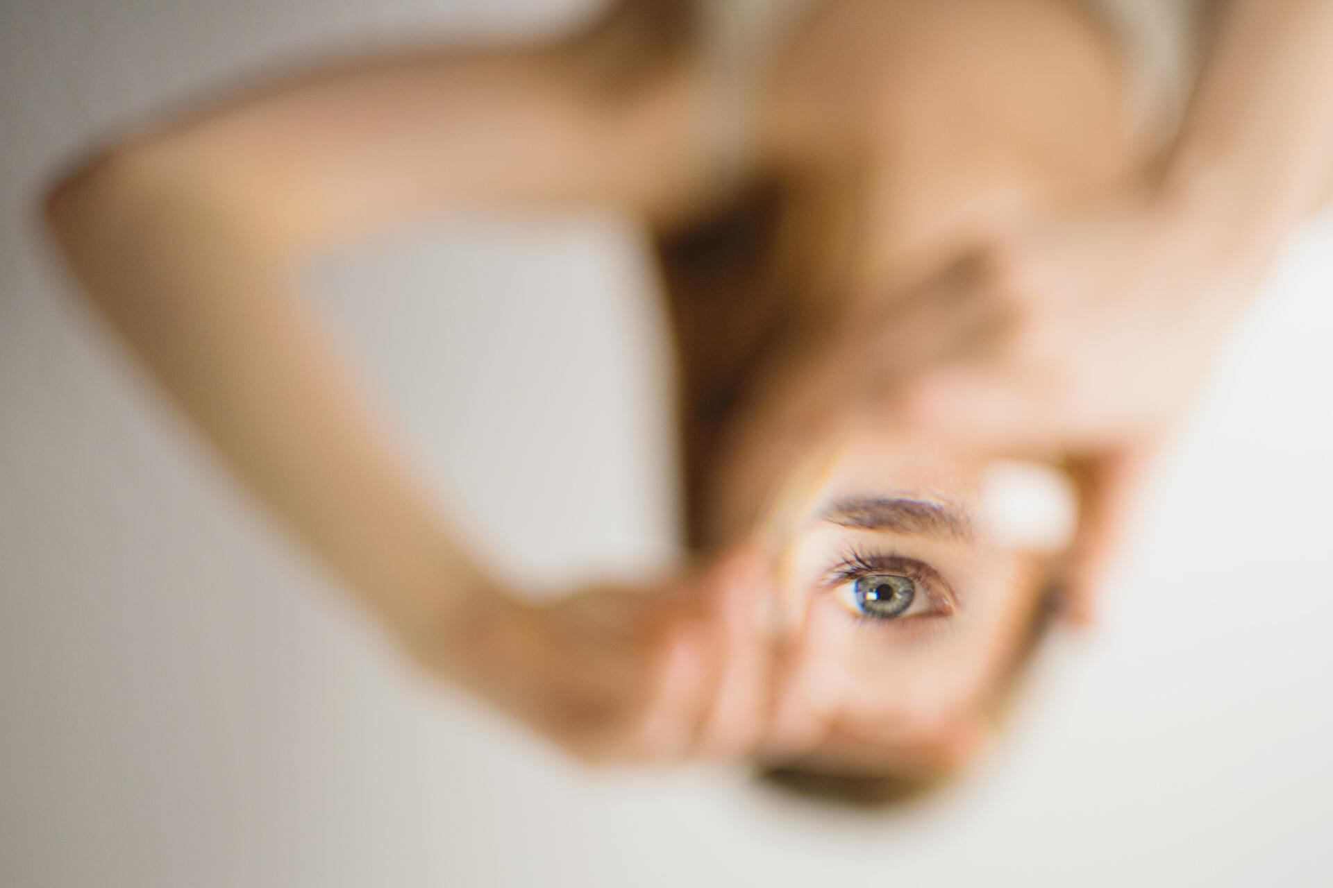 A close up of a woman 's face with her hand on her face.