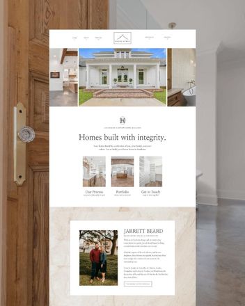 A website for a real estate company is displayed on a wooden door.