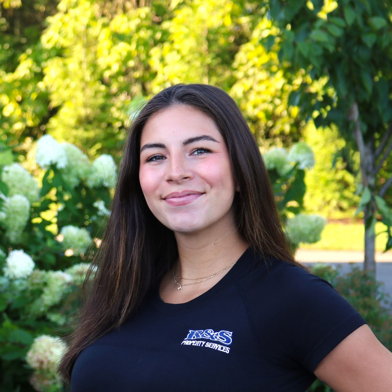 R&S Property Services Employee Headshot of Woman in front of Green Turf Wall