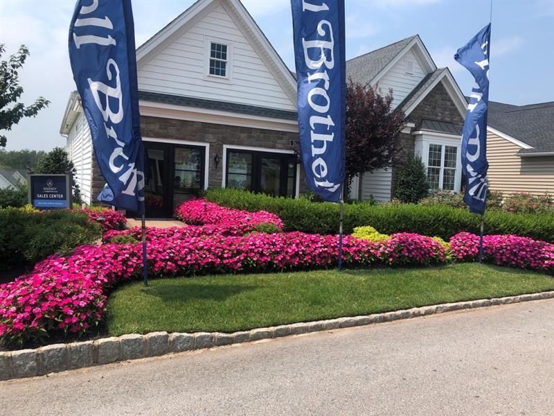 a newly installed Devon, PA landscape featuring fresh grass, flower displays, shrubs and walkways