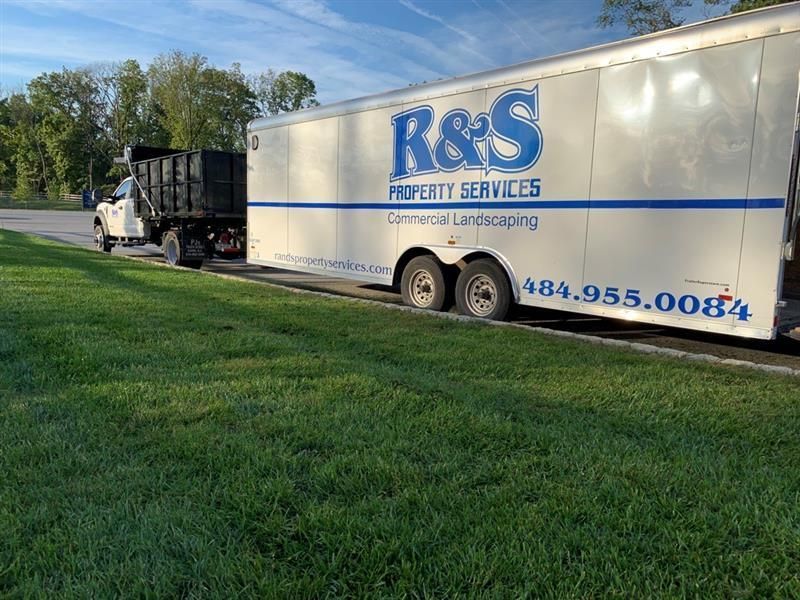 R&S Property Services work truck and trailer parked in front of a client’s recently cut lawn