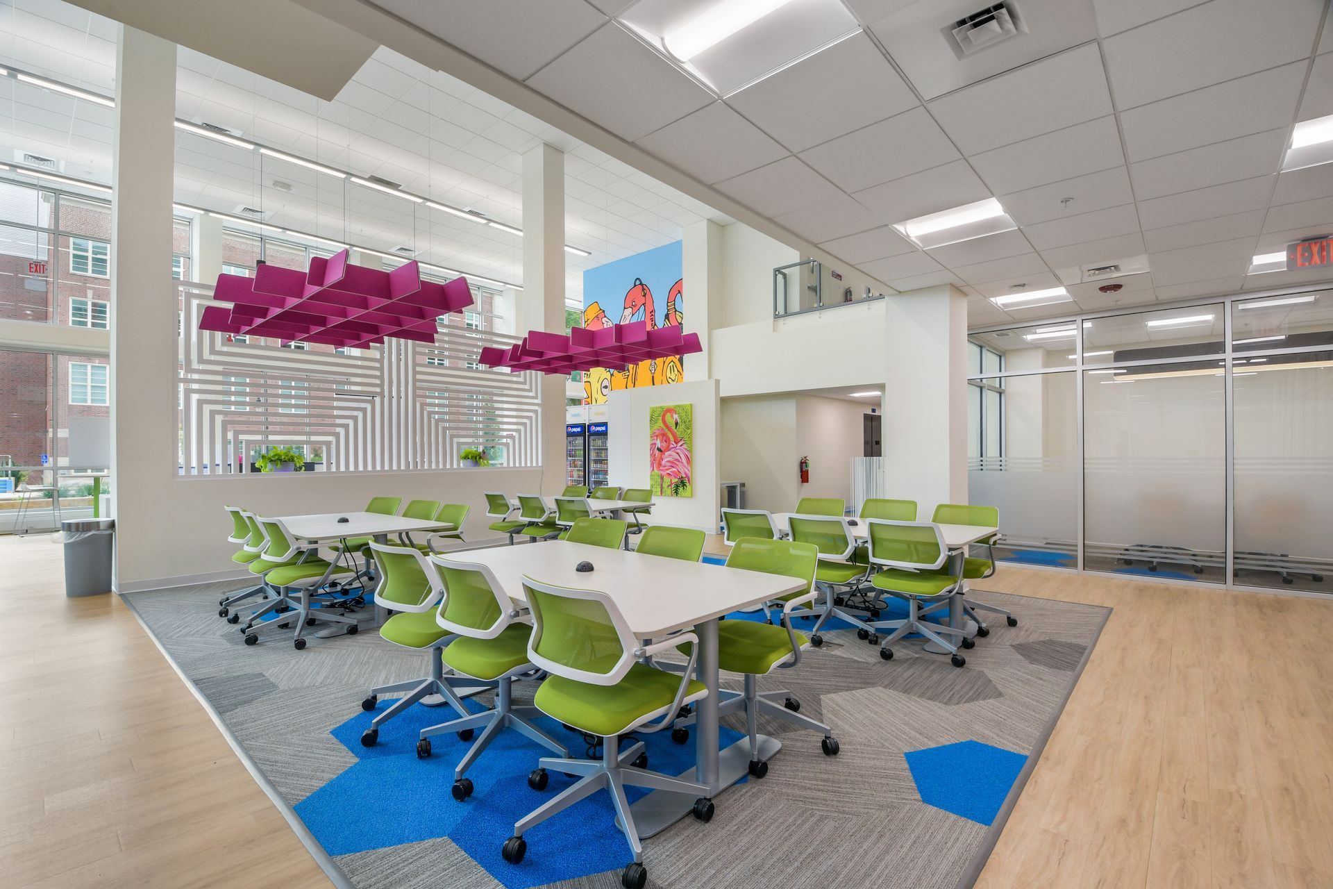 Open-concept kitchen and living area with stainless steel appliances, light wood cabinets, and light wood flooring.