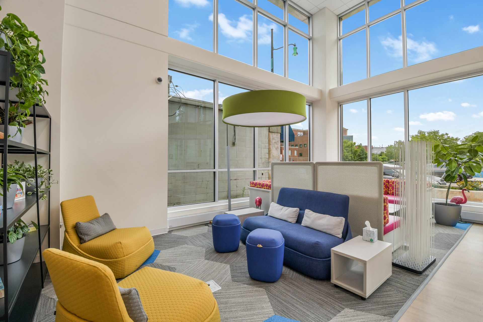 Open-concept kitchen and living area with stainless steel appliances, light wood cabinets, and light wood flooring.