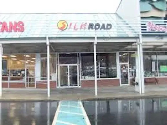 A store front with a handicapped parking spot in front of it.