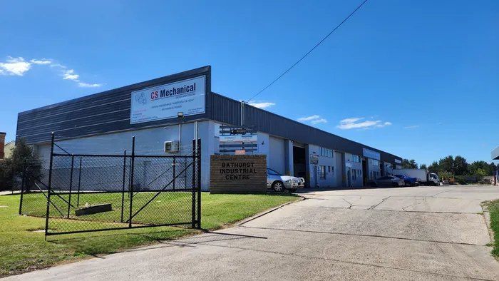 A Large Building With a Fence Around It and a Car Parked in Front of It — CS Mechanical in Gormans Hill, NSW