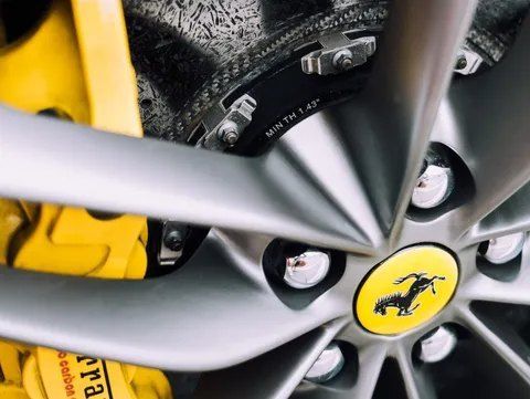 A Close Up of a Ferrari Wheel With Yellow Brake Calipers — CS Mechanical in Gormans Hill, NSW
