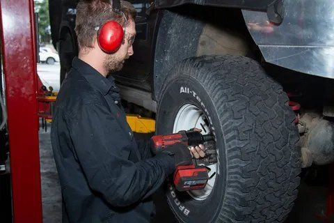 A Man Wearing Headphones is Working on a Tire on a Lift — CS Mechanical in Gormans Hill, NSW