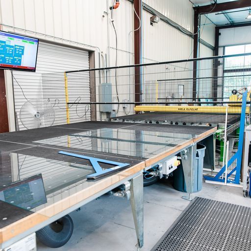 A Large Glass Table in A Factory with A Monitor Above It - Buford, GA - EGM Tempering