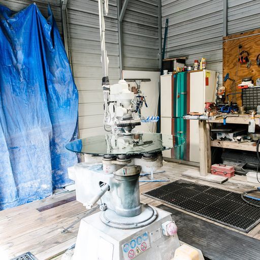 A Machine Is Sitting in A Room with A Blue Tarp on The Wall - Buford, GA - EGM Tempering