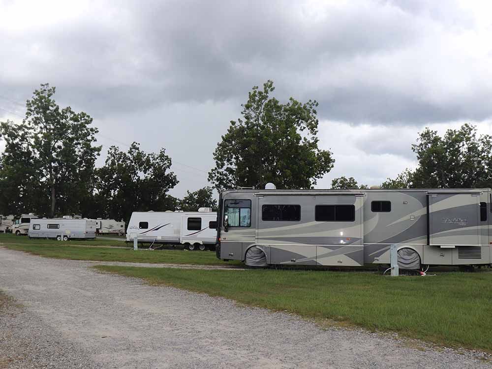 A group of rvs are parked in a grassy area.