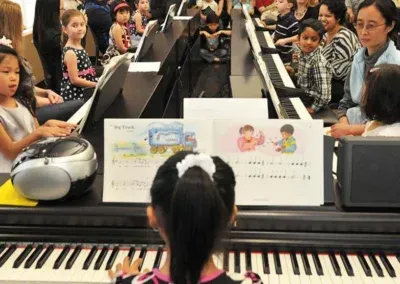 Children playing the piano during a group lesson