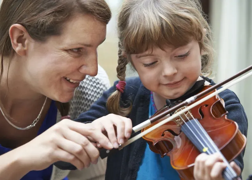 young girl learning to play the violin