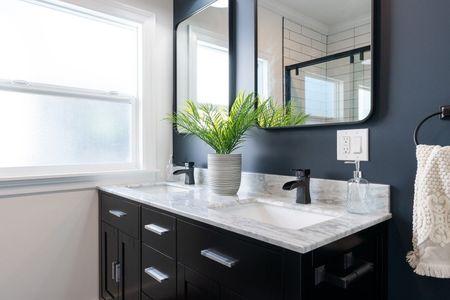 Custom made bathroom cabinet vanity with black base cabinet and marble countertop.