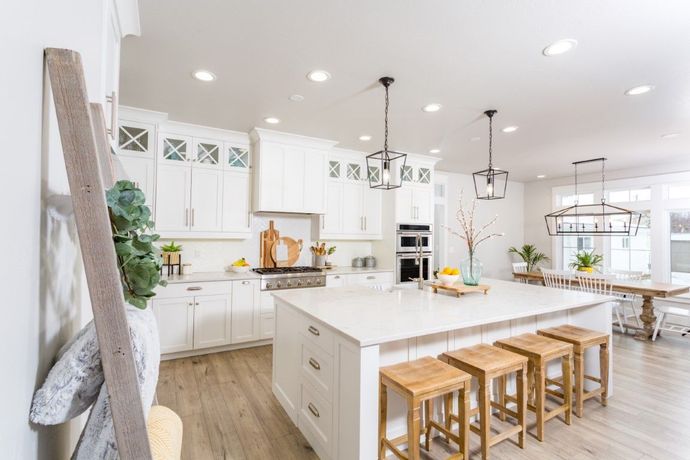 White kitchen with custom cabinets that extend to the ceiling and kitchen custom made island with side drawers.