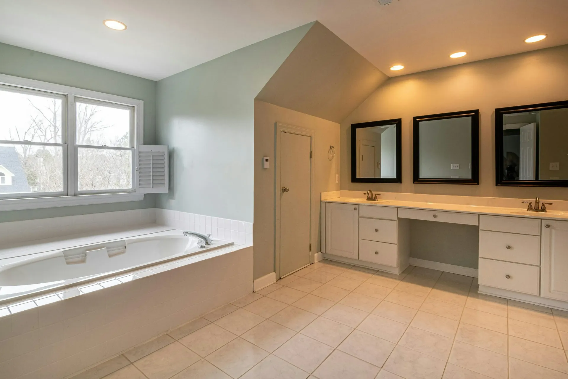 Bathroom remodel with custom built white cabinet vanity with two sinks, cupboards and drawers.
