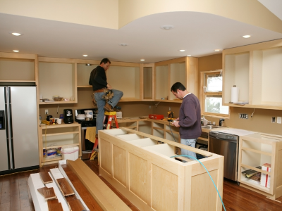 A kitchen in the process of being updated for new cabinets include a center island cabinet.