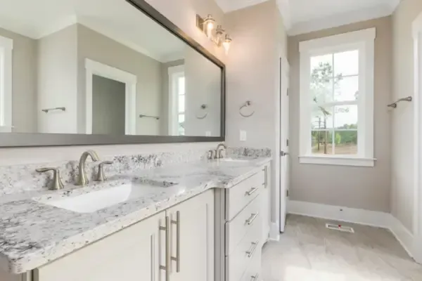 Custom built bathroom cabinet vanity with white base cabinets with cupboards and drawers with marble countertop.