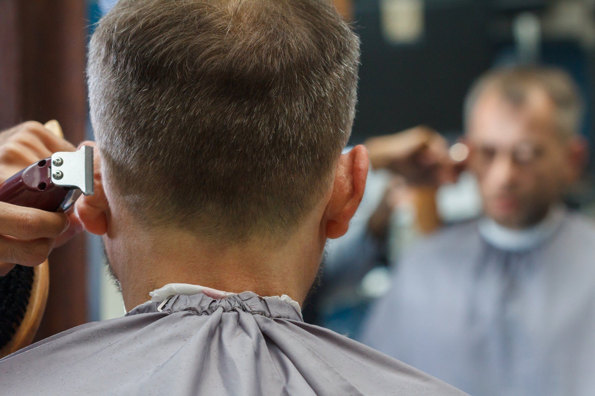 Men’s Barbershop — Male Client Getting Haircut by Hairdresser in Wilmington, DE