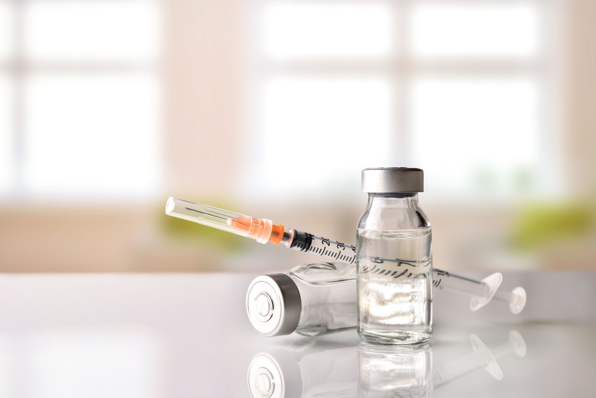 A syringe is sitting next to a bottle of liquid on a table.
