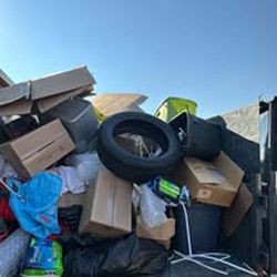 A pile of trash is sitting in the back of a truck.