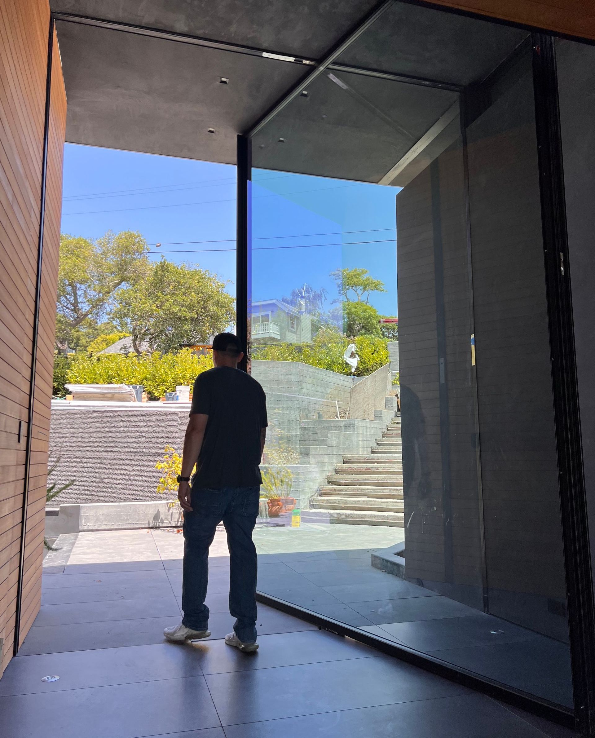 Man walking through big glass pivot door