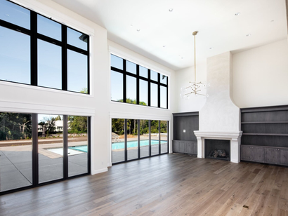 Big doors in open living room looking onto pool in backyard