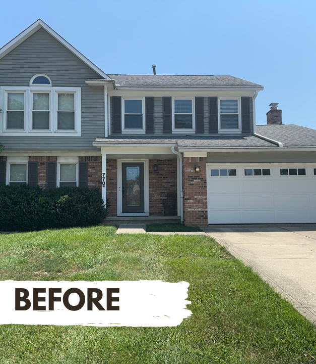 Two-story tan house with porch and dormer. Green lawn and sidewalk in front.