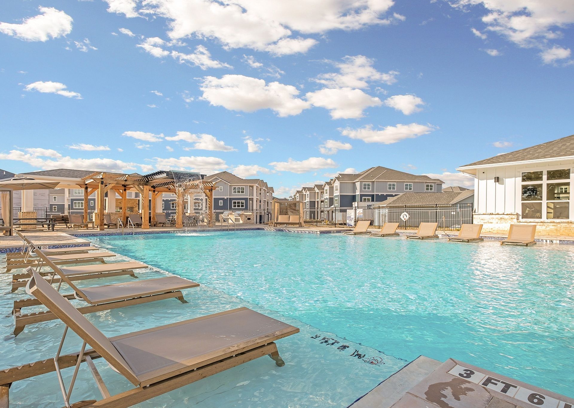 A large swimming pool with a lot of chairs around it