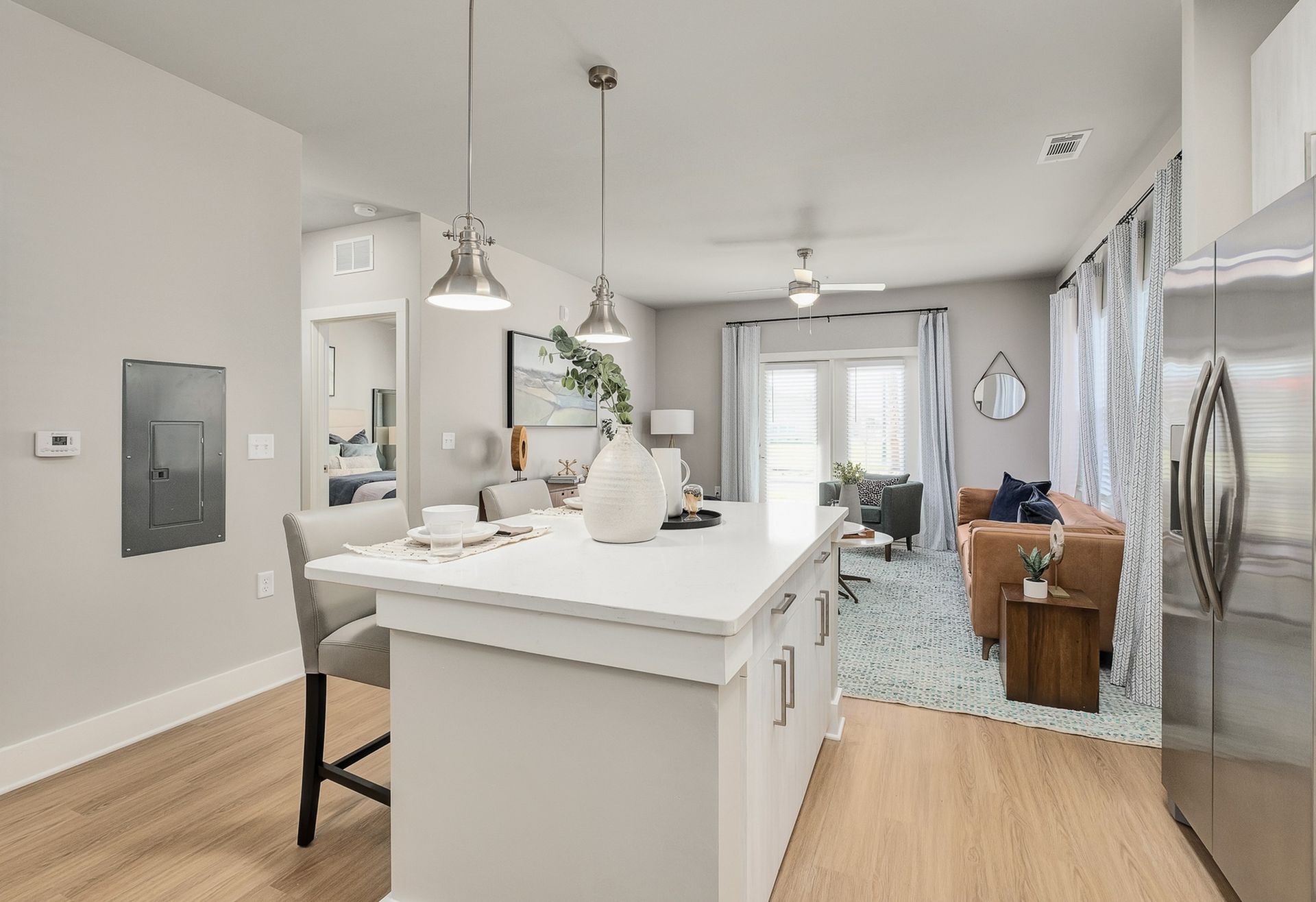 A kitchen with a large island and a stainless steel refrigerator.