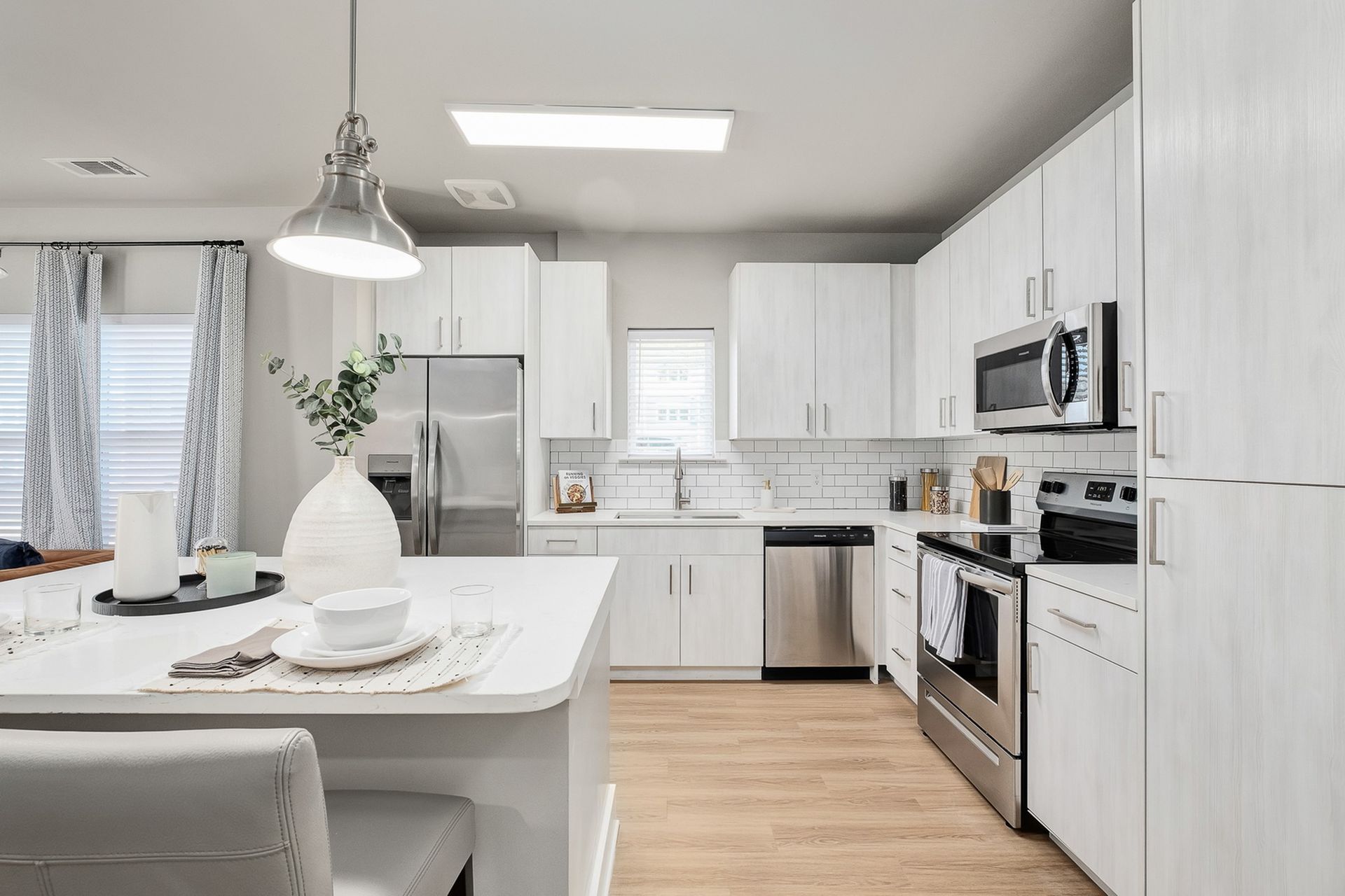 A kitchen with white cabinets and stainless steel appliances.