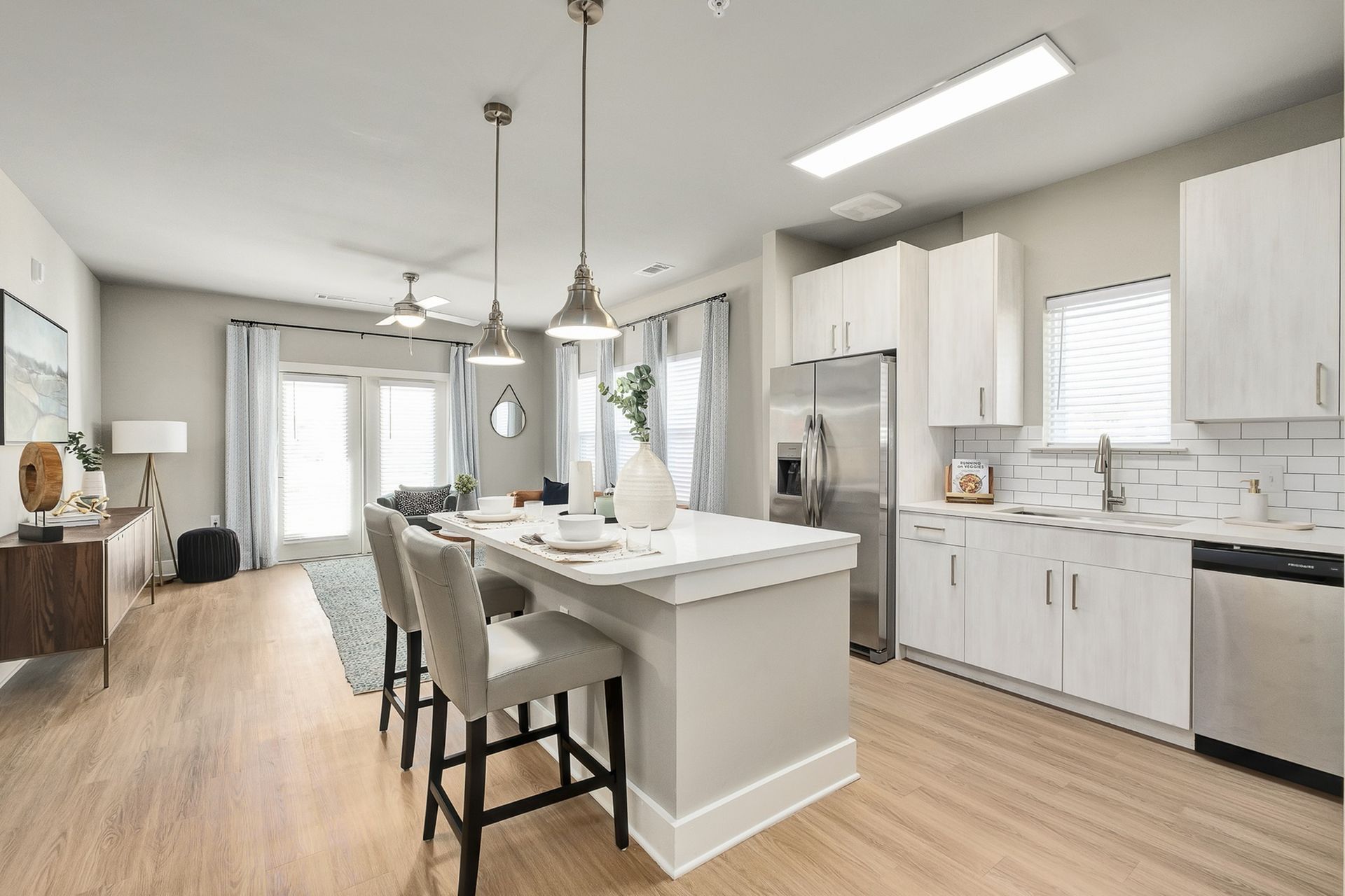 A kitchen in a house with white cabinets and stainless steel appliances.