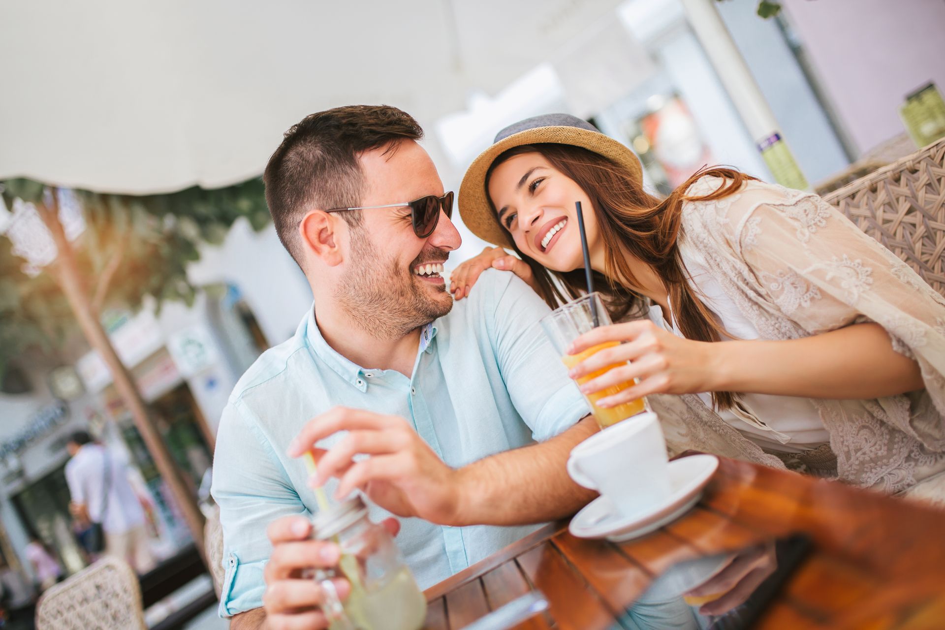 A man and a woman are sitting at a table with drinks.