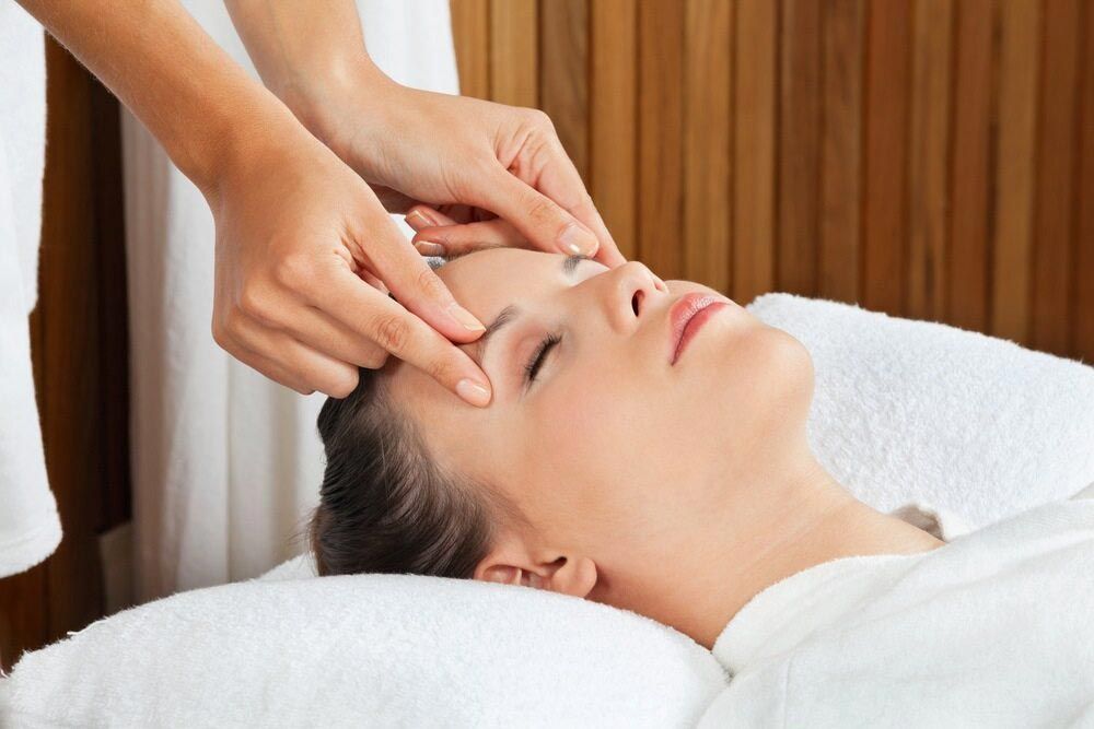 A Woman Is Getting A Facial Massage At A Spa — Phoenix Mandorla In Rockhampton City, QLD