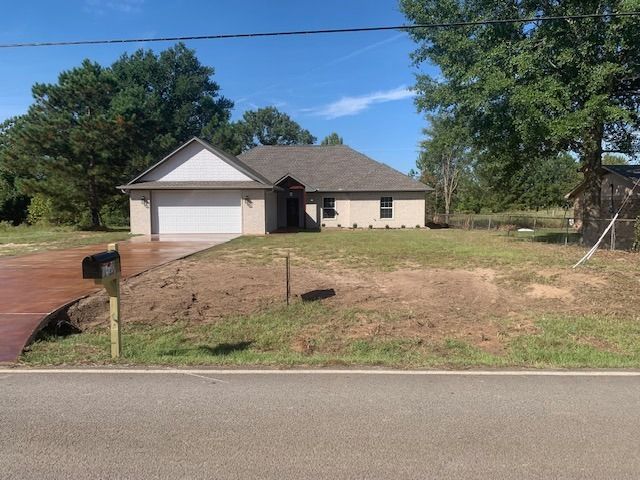 A house with a driveway and a mailbox in front of it