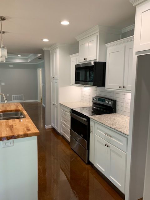 A kitchen with white cabinets and stainless steel appliances