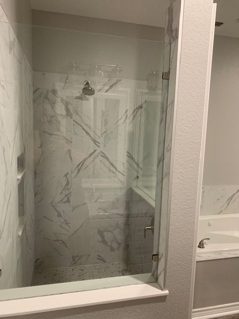 A bathroom with a walk in shower and a bathtub.