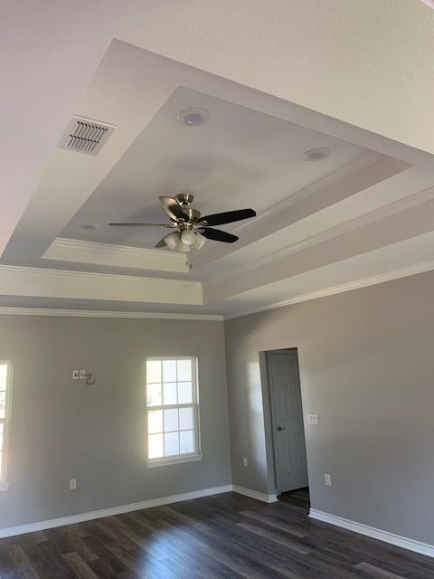 A living room with a ceiling fan and a window.