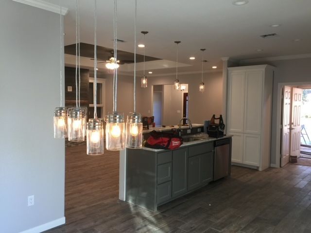 A kitchen with a lot of lights hanging from the ceiling