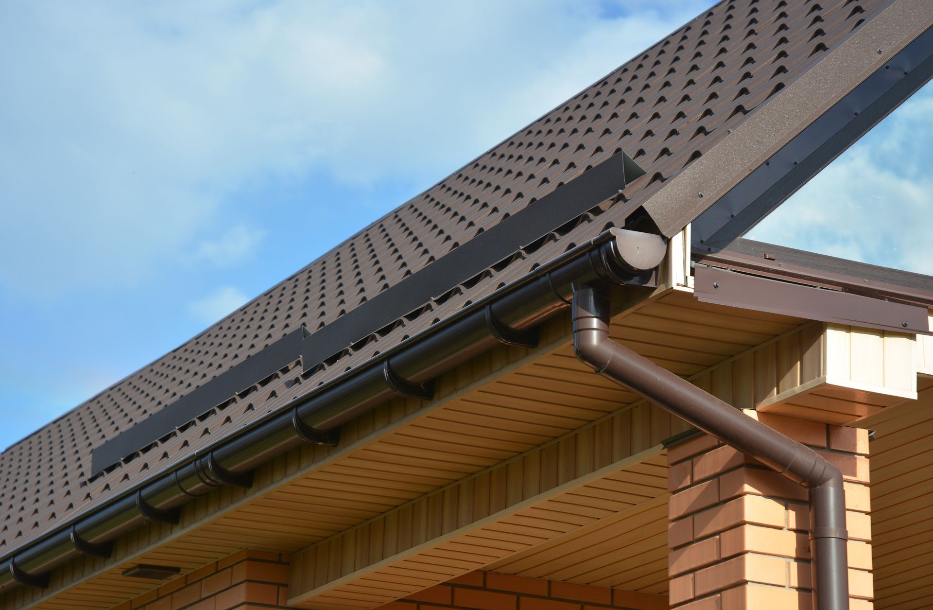 A close up of a gutter on the roof of a house.