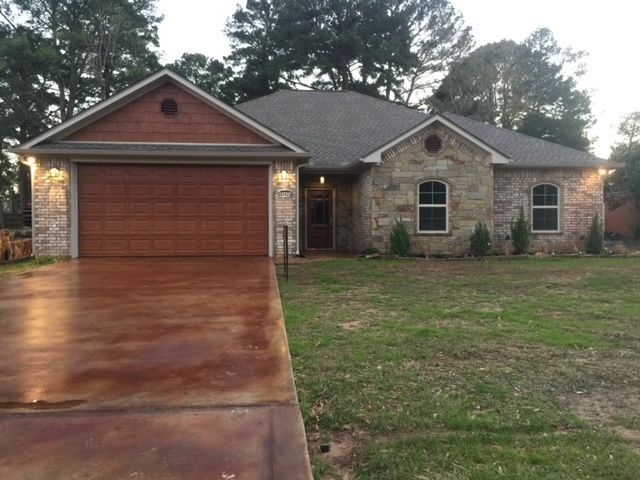 A house with a large garage door and a driveway in front of it.