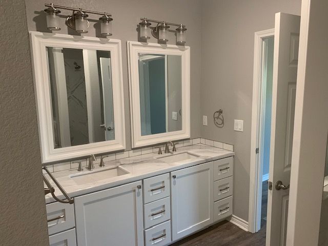 A bathroom with two sinks and two mirrors.
