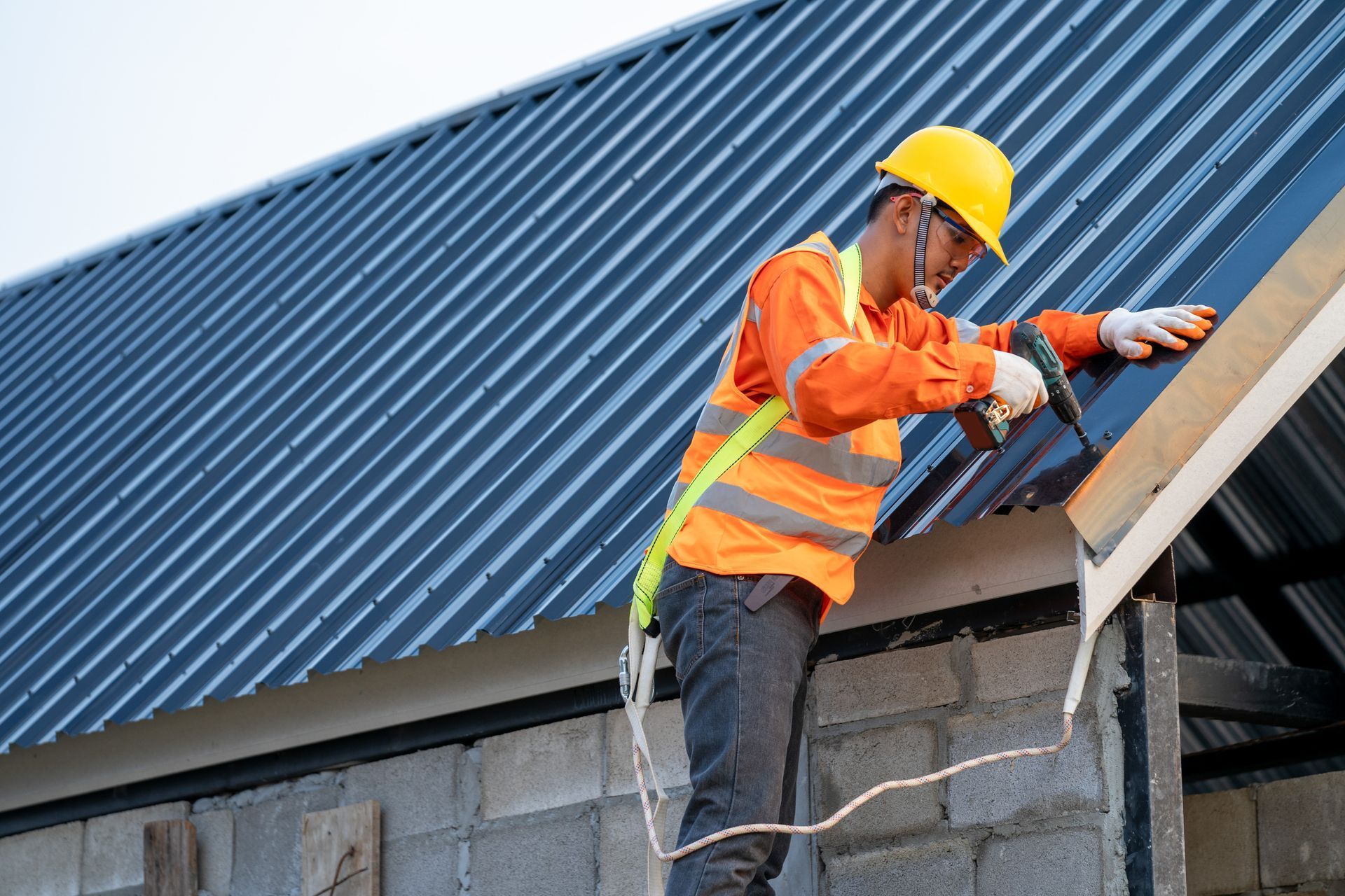 A construction worker is working on the roof of a building.