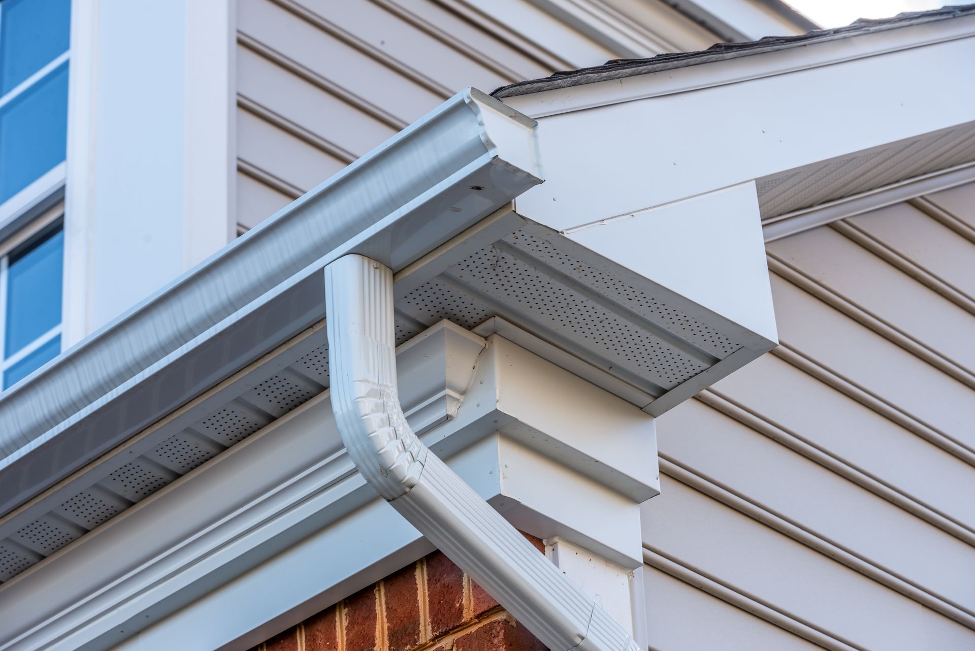 A close up of a gutter on the side of a house.