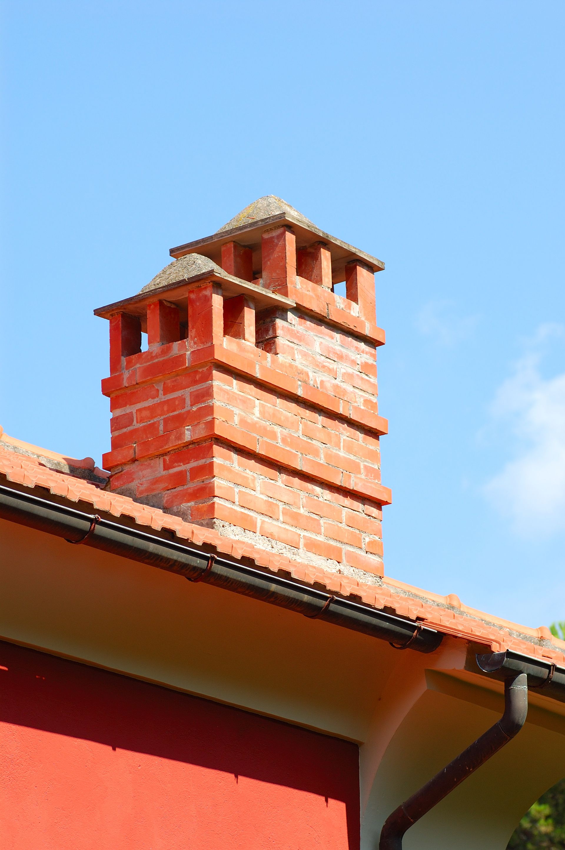 A red brick chimney on the roof of a house