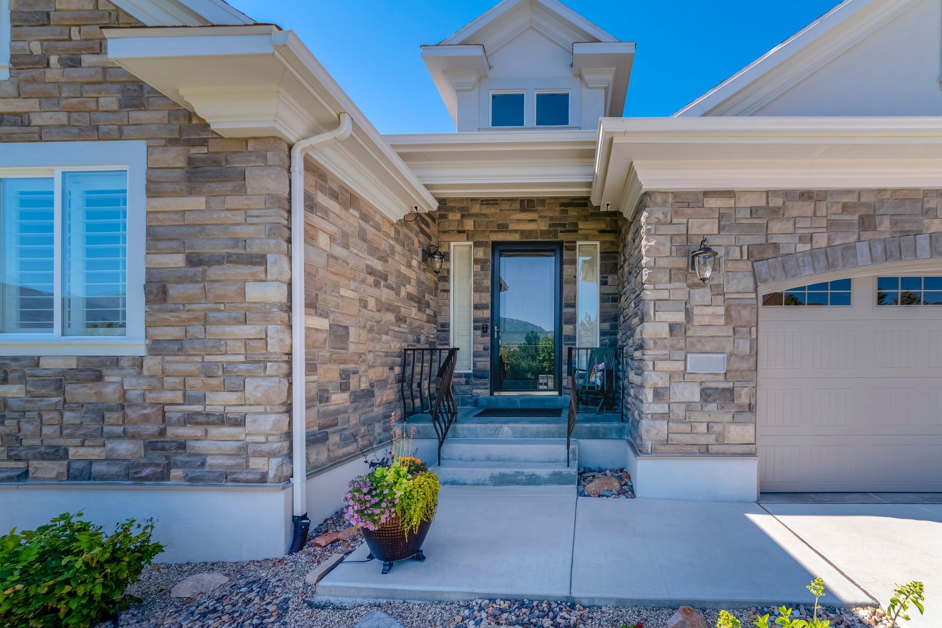 A house with a stone facade and a white garage door