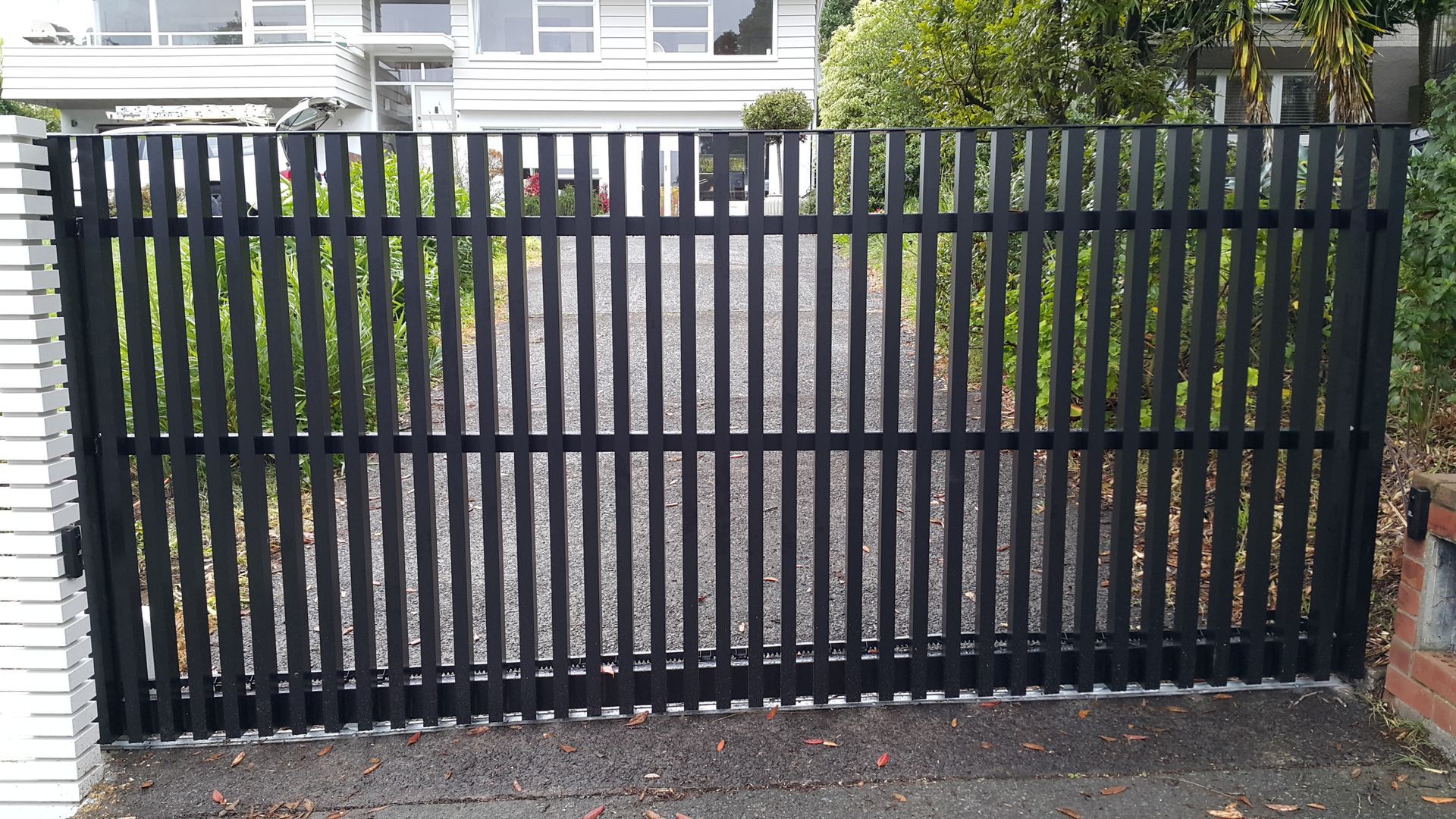 A black fence is sitting in front of a house.